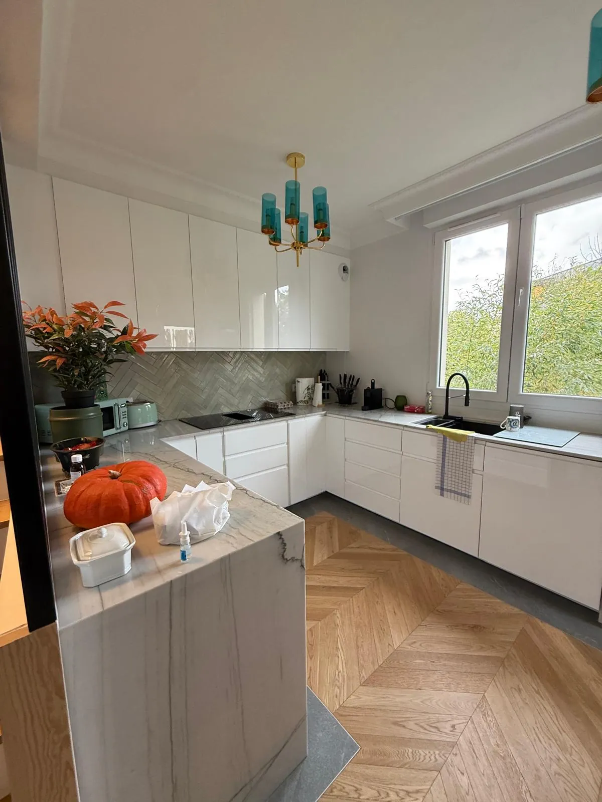 Cuisine rénovée avec crédence en chevrons et parquet point de Hongrie par Solarius Deco
